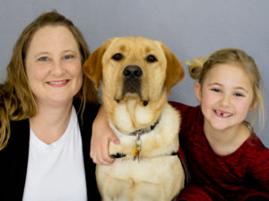 mother and daughter with Labrador Retriever between them