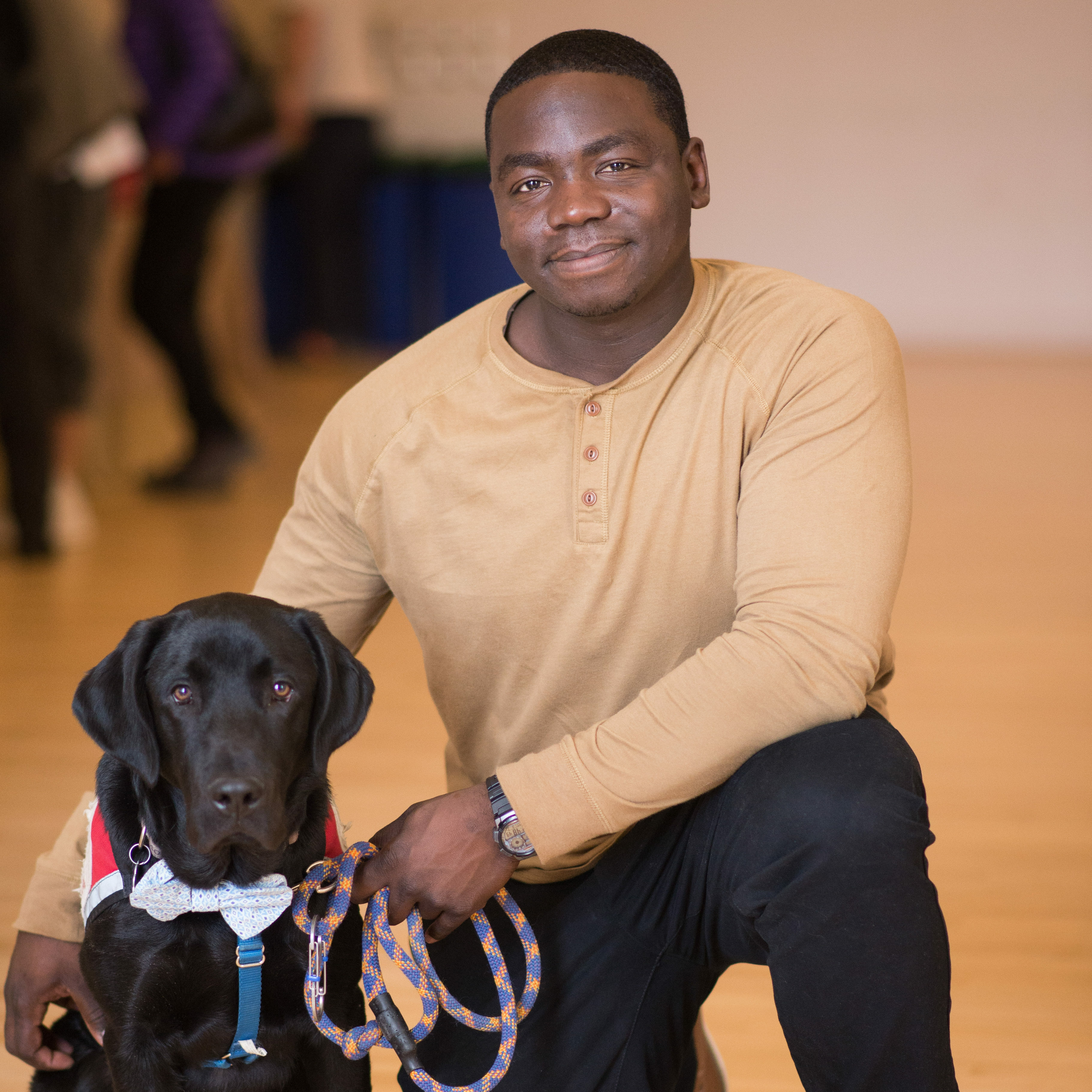 Man kneeling with black dog