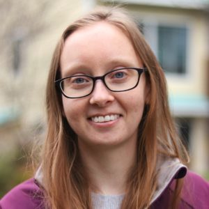 image of a smiling woman with straight blonde hair in brown-rimmed glasses